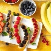 Colazione sana a base di banana split Chiquita con frutti rossi e burro di arachidi